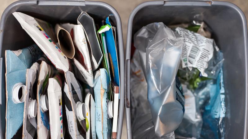 Två kärl med pappersförpackningar och plast.