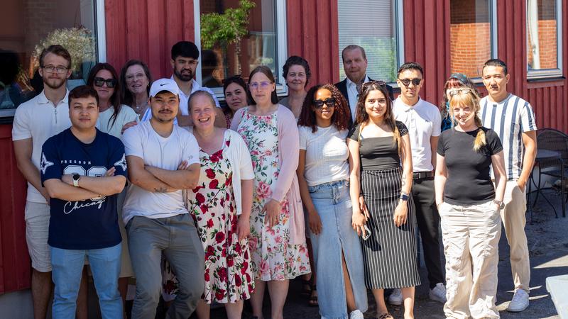 Gruppbild på omkring 20 glada och sommarklädda personer.