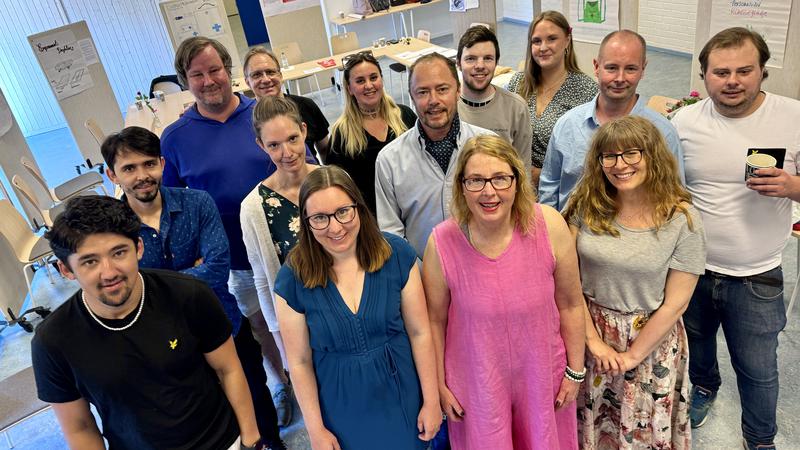 Guppbild på ett 15-tal ersoner i olika åldrar i en undervisningssal