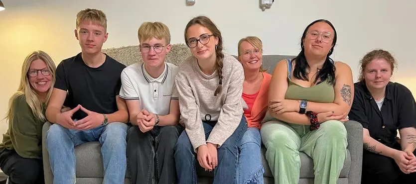 En grupp människor som sitter på en soffa.