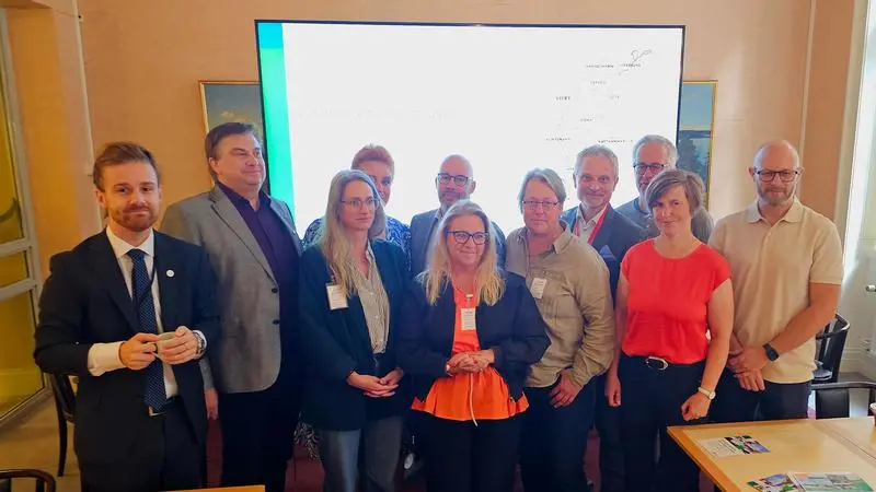 11 personer på gruppbild med Gotlands karta i bakgrunden