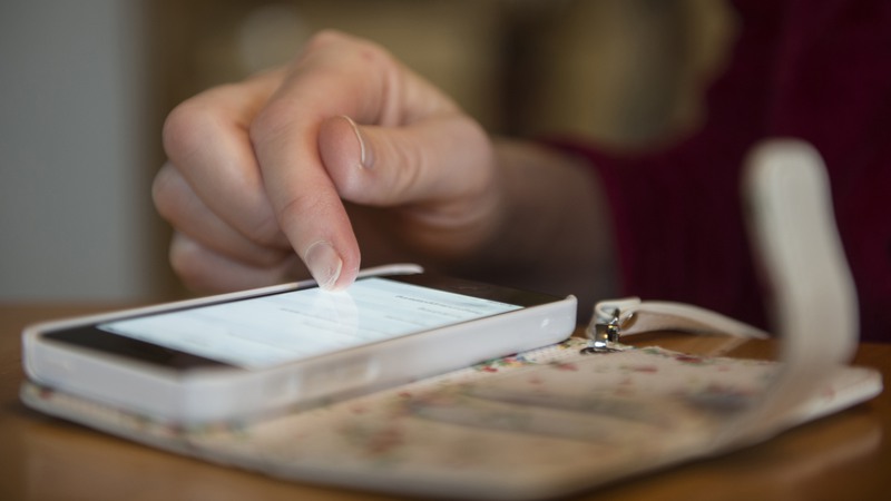 Bild på hand och mobiltelefon