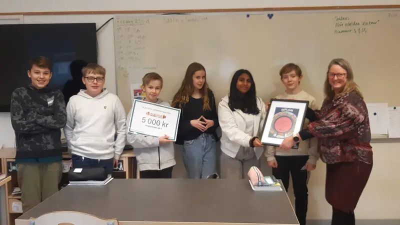 Skolelever i ett klassrum tar emot pris