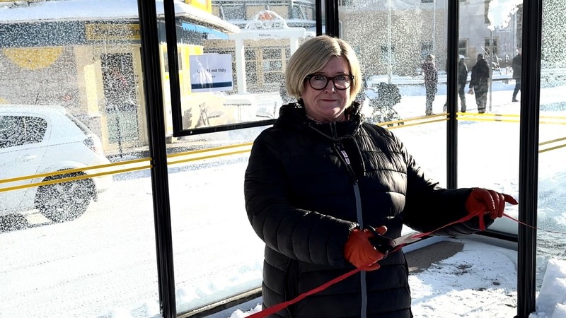 Kvinna klipper rött band i en nybyggd busskur