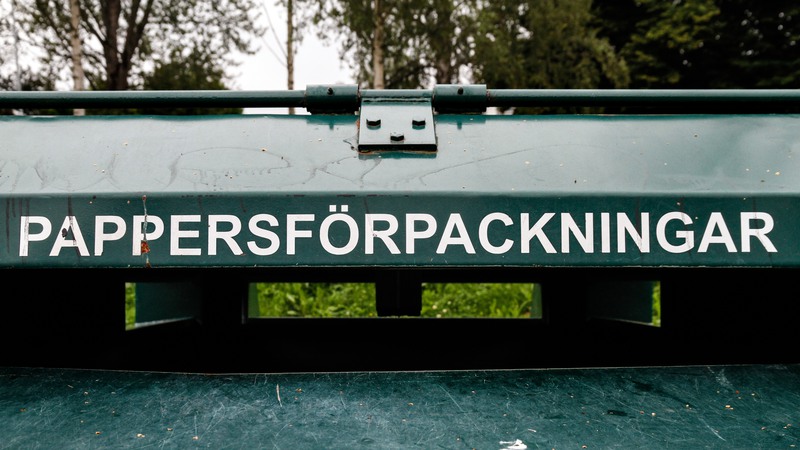 Grön container märkt med "pappersförpackningar".