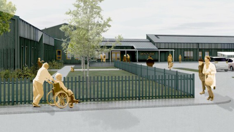 Skiss av Klintehamns nya äldreboende, en låg mörkgrå byggnad med staket runt.