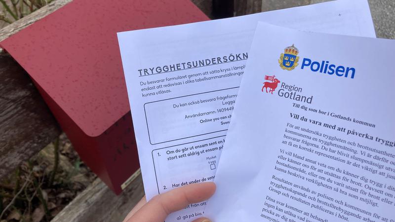 En hand håller i en enkät och ett informationsblad om trygghetsmätningen.
