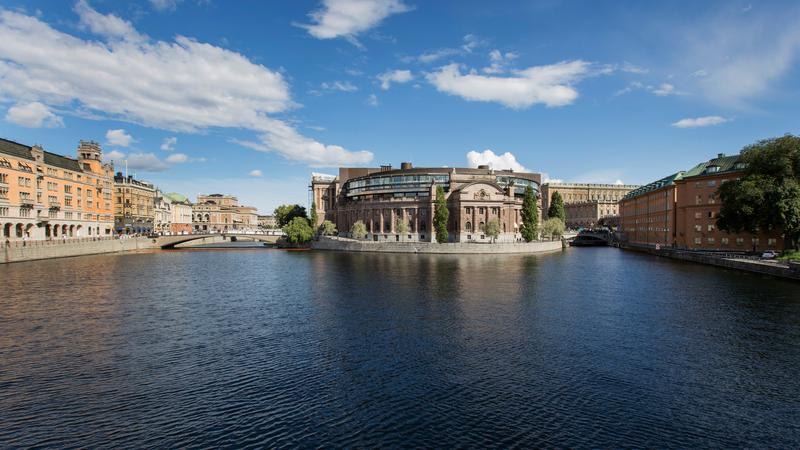 Stor rundad byggnad med vattendrag i förgrunden