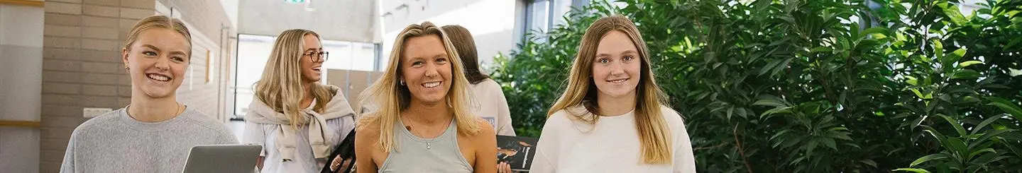 Glada gymnasielever i korridor