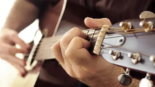 Man som spelar akustisk gitarr