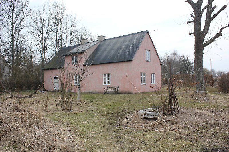 Ett rosa hus med vita fönster.