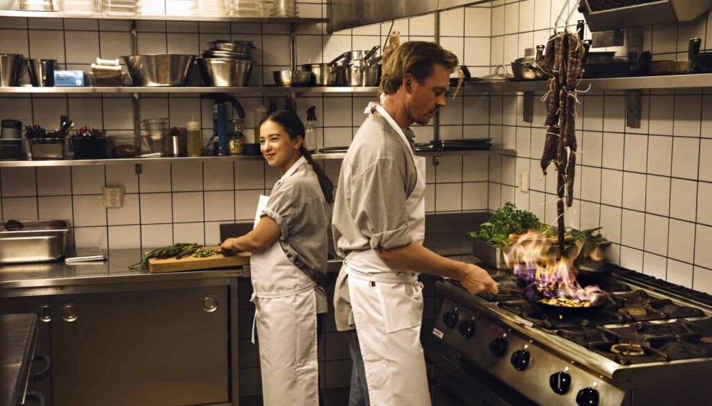 kvinna och man lagar mat i restaurangkök