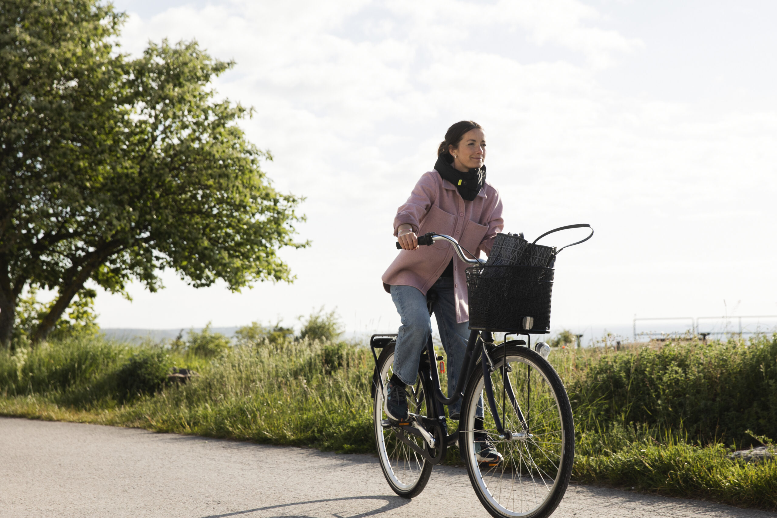 Kvinna som cyklar längs havet