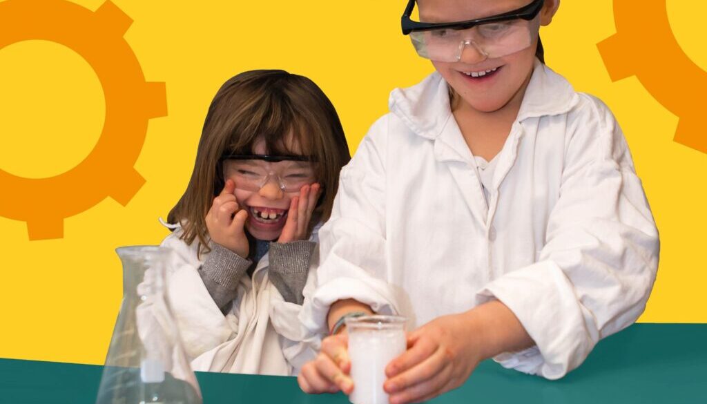 Två skrattande barn i skyddsglasögon gör experiment
