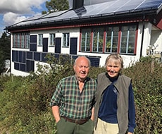 Par framför hus med solceller på tak