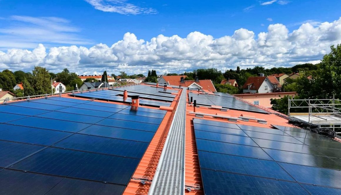 Tak med solceller i bakgrunden villaområde