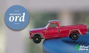 Röd leksaksbil som balanserar med framhjulen i luften