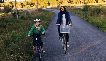 Barn och kvinna som cyklar på landsväg