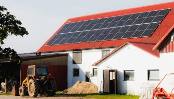 Rött ladugårdstak med solpaneler installerade.