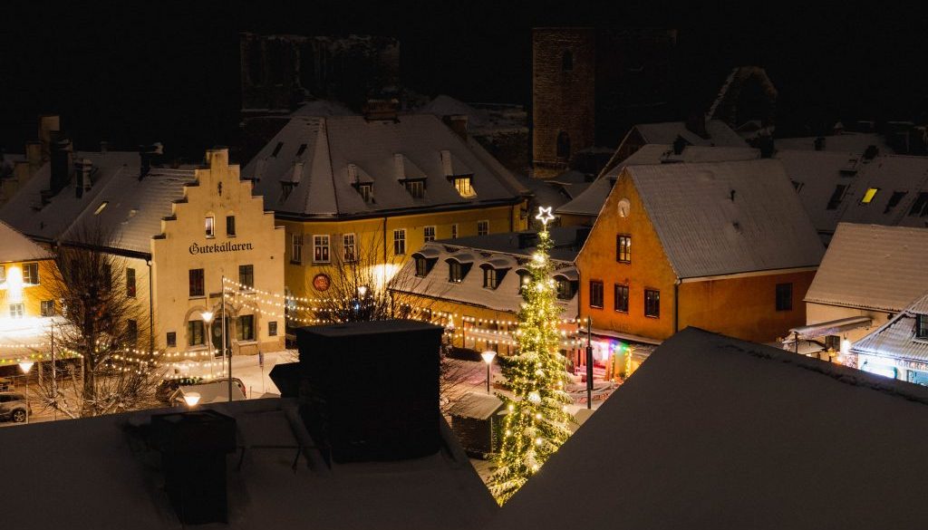 Överblick av julbelysning gran och snötäckta tak på Stora torget i Visby