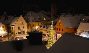 Överblick av julbelysning gran och snötäckta tak på Stora torget i Visby