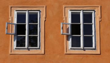 windows-941625_1920 två fönster med spröjs på en orangefärgad husfasad