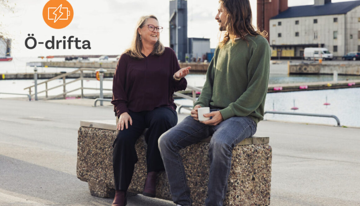 två personer sitter på en bänk i Visby hamn och pratar. Logo Ö-drifta uppe i vänster hörn.
