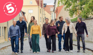 Några personer går och samtalar i en gränd i Visby. Illustration: Energicentrum 5 år!